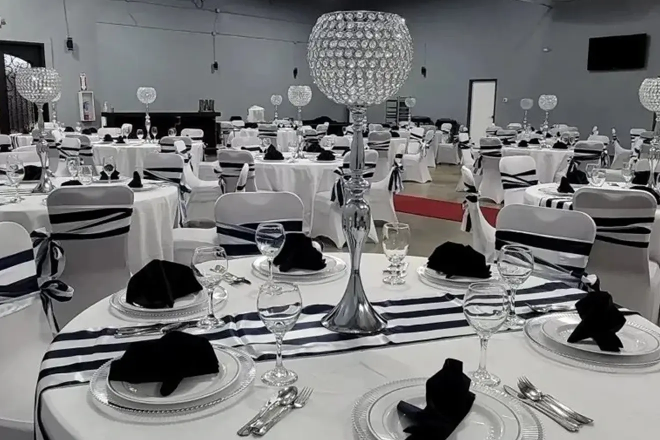 A black and white photo of tables set for an event.